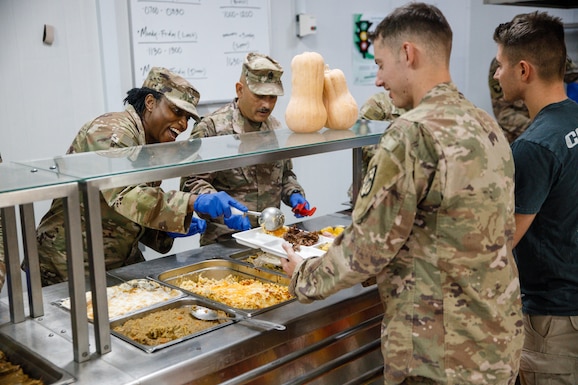 U.S. Army Col. Tanya Simmons, the deputy commanding officer of the 364th Expeditionary Sustainment Command, and Command Sgt. Maj. Daniel Quintana, command sergeant major, 17th Sutainment Brigade, serve Thanksgiving dinner in the U.S. Central Command area of responsibility, Nov. 28, 2024. DLA Subsistence begins coordination in the Spring to ensure servicemembers around the globe have a taste of home during the Thanksgiving holiday. (U.S. Army photo by Sgt. Adrianne Lopez)