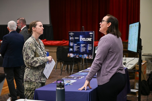 Cmdr. Brittany Yang, deputy program director, Navy Medical Modeling and Simulation Training (NMMAST), speaks to a vendor during the Joint Trauma System Combat Casualty Care Simulation Expo at Joint Base San Antonio-Lackland, Nov. 13, 2025. The NMMAST program, housed within the Naval Medical Forces Development Command enterprise, serves as the central hub for identifying, evaluating, validating, and overseeing the use and implementation of new and emerging advanced learning technologies and methodologies to support medical education and training for healthcare teams and patients for the purpose of improving overall health-related outcomes.  (U.S. Navy photo by Mass Communication Specialist 1st Class Shayla D. Hamilton)