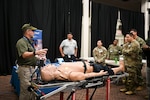 Service members watch a mannequin performance demonstration during the Joint Trauma System Combat Casualty Care Simulation Expo at Joint Base San Antonio-Lackland, Nov. 13, 2025. (U.S. Navy photo by Mass Communication Specialist 1st Class Shayla D. Hamilton)