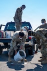 A photo of Airmen pouring concrete, smoothing concrete and observing the filling of a hole on an airfield.