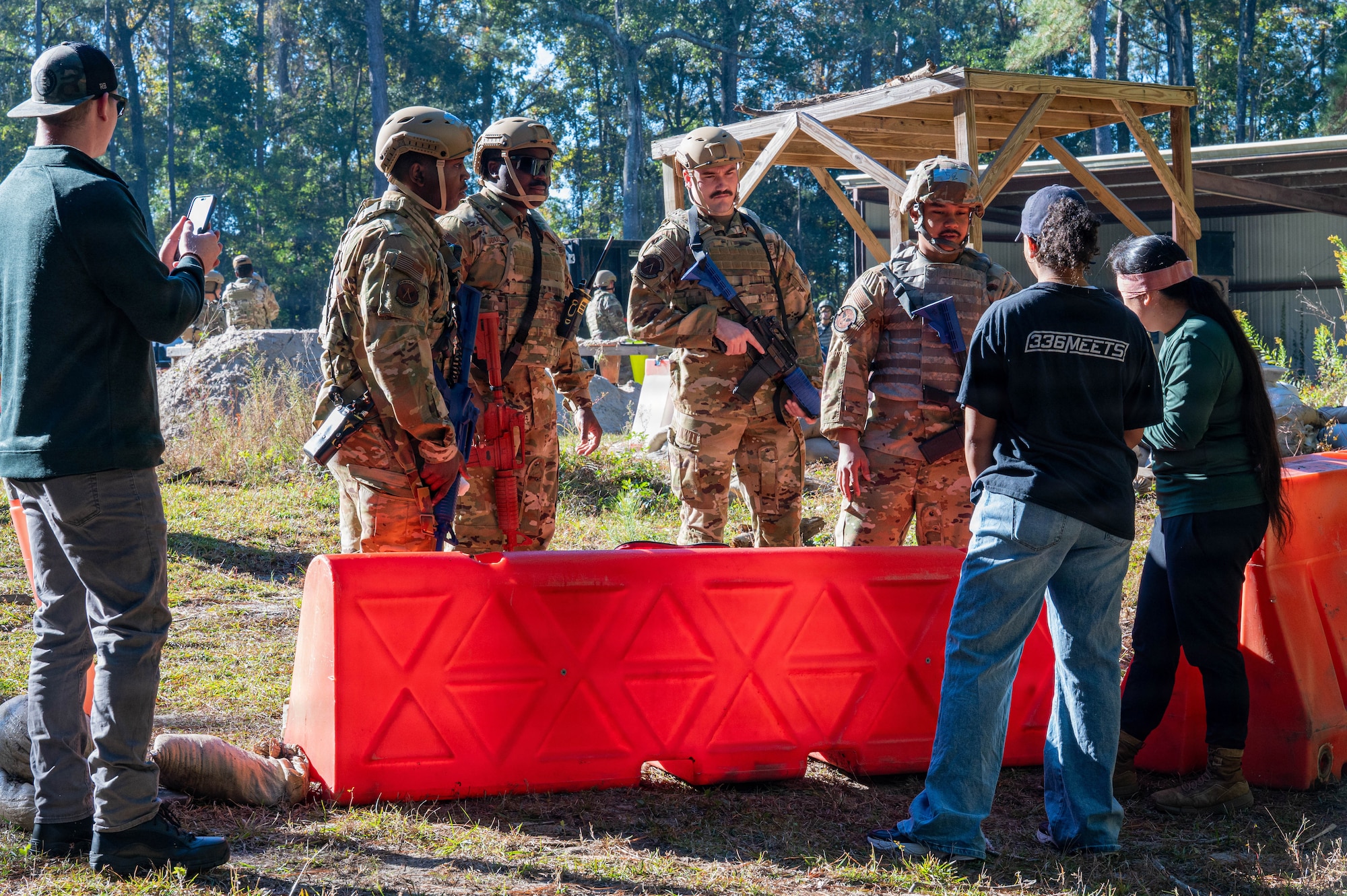 A photo of Airmen standing behind a barricade.