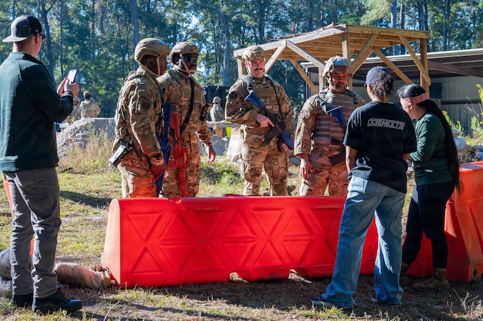 A photo of Airmen standing behind a barricade.