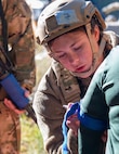 A photo of a female Airman writing on the arm of a patient