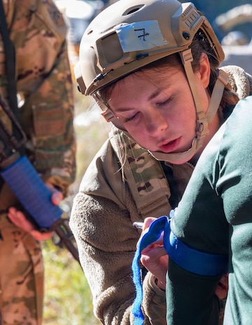 A photo of a female Airman writing on the arm of a patient