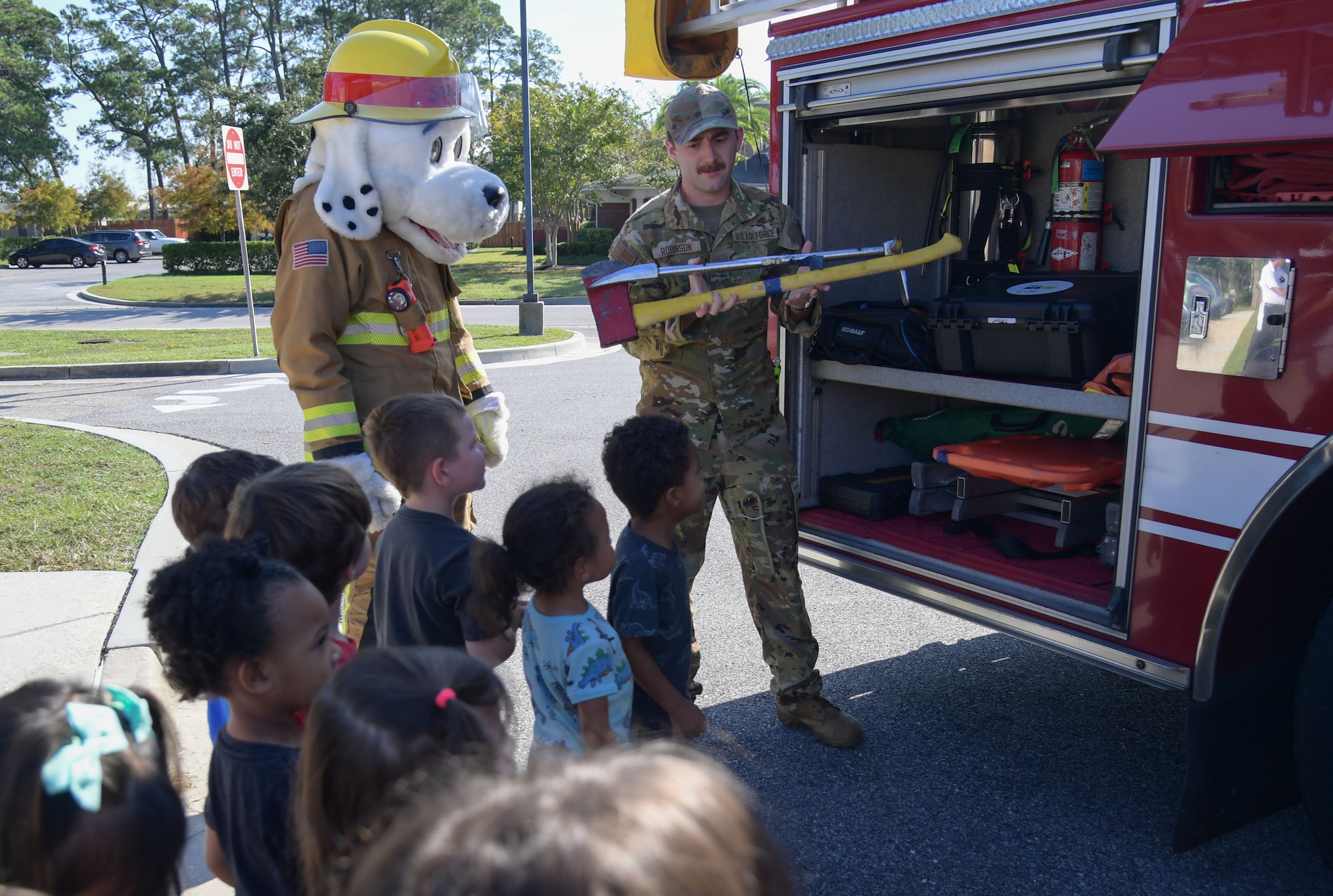 A firefighter shows firefighting tools to children