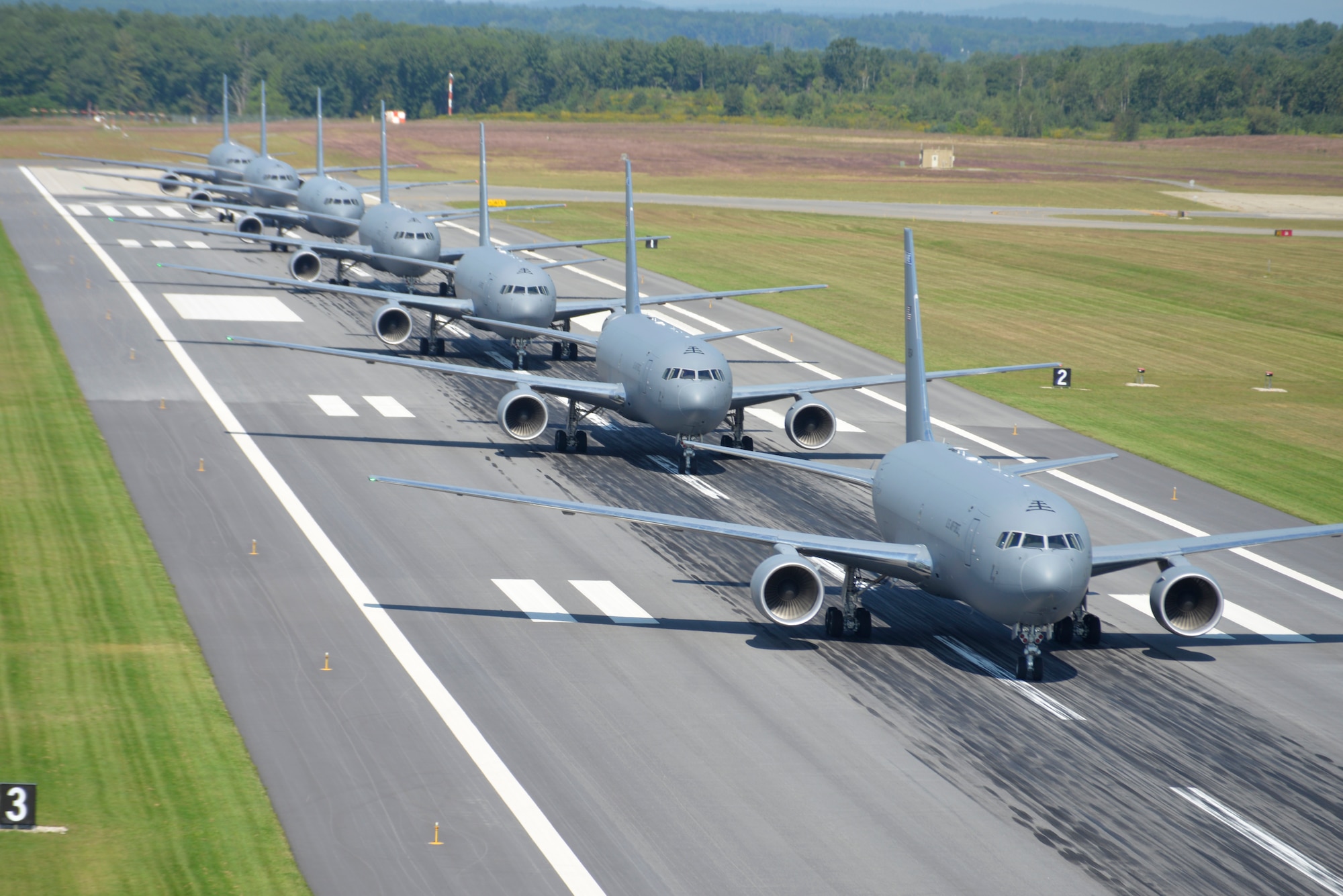 U.S. Air Force KC-46A aircraft assigned to the 157th Air Refueling Wing, New Hampshire National Guard, are lined up in formation on the runway at Pease Air National Guard Base
