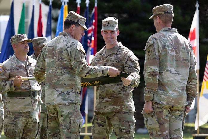 Col. Sean Heidgerken and Command Sgt. Maj. Avery Bennett, the 1st Theater Information Advantage Detachment command team, uncase the unit guidon as part of the unit’s activation ceremony November 7, 2025, at Fort Shafter, Hawaii.