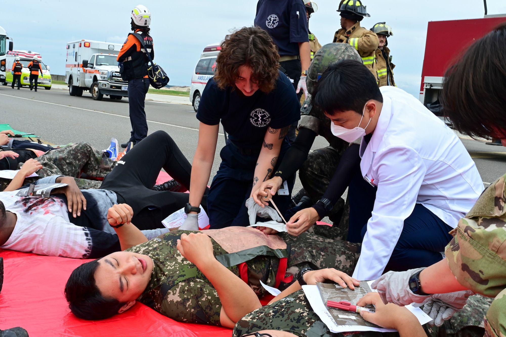 A man helps a patient on the ground.