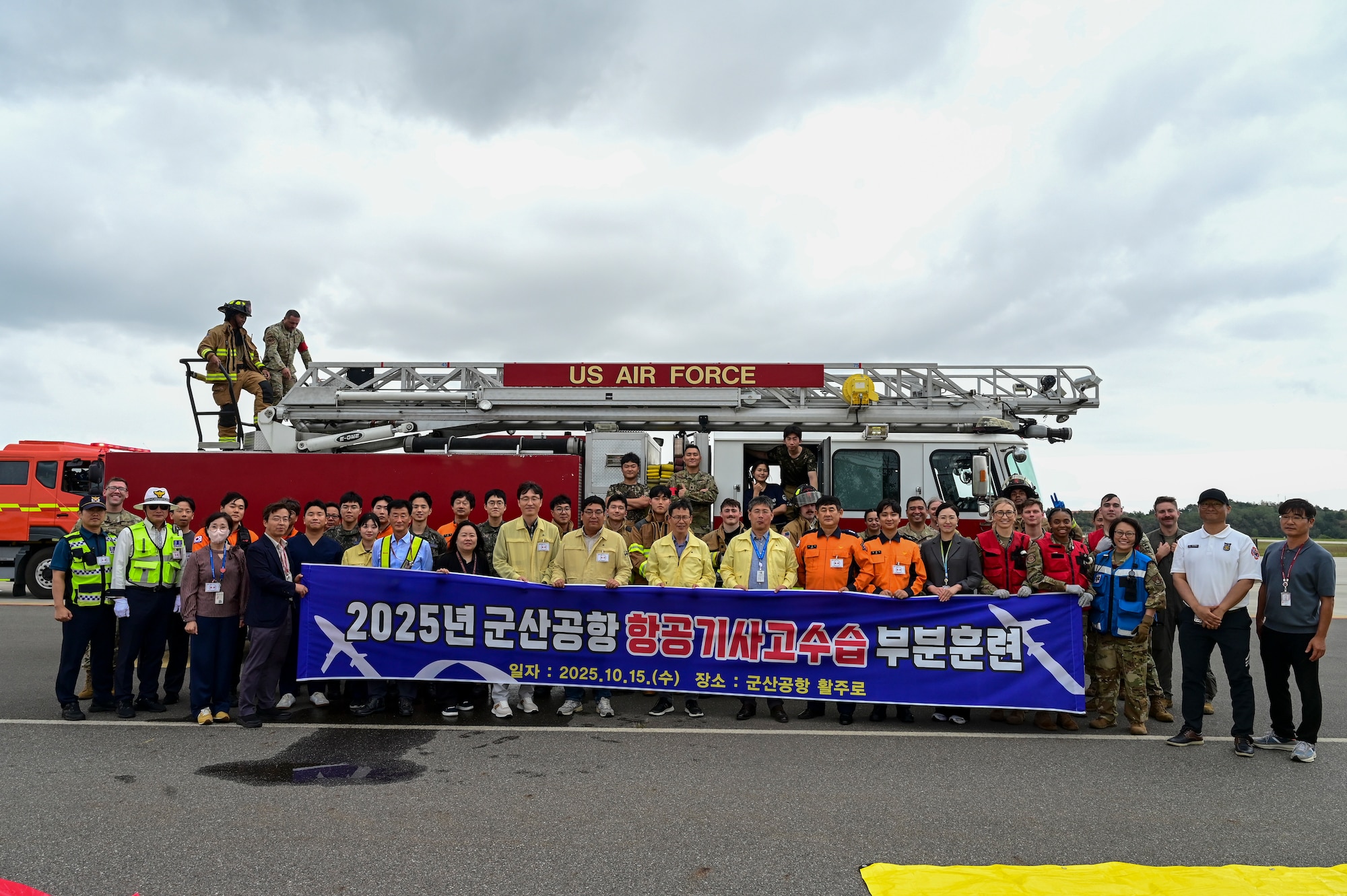 A group poses in front of a firetruck.