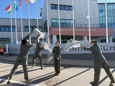 U.S. Air Force student pilots celebrate after completing a T-346A Master Jet Trainer sortie during the undergraduate flying training program Small Group Tryout at the International Flight Training School, Decimomannu Air Base, Italy.