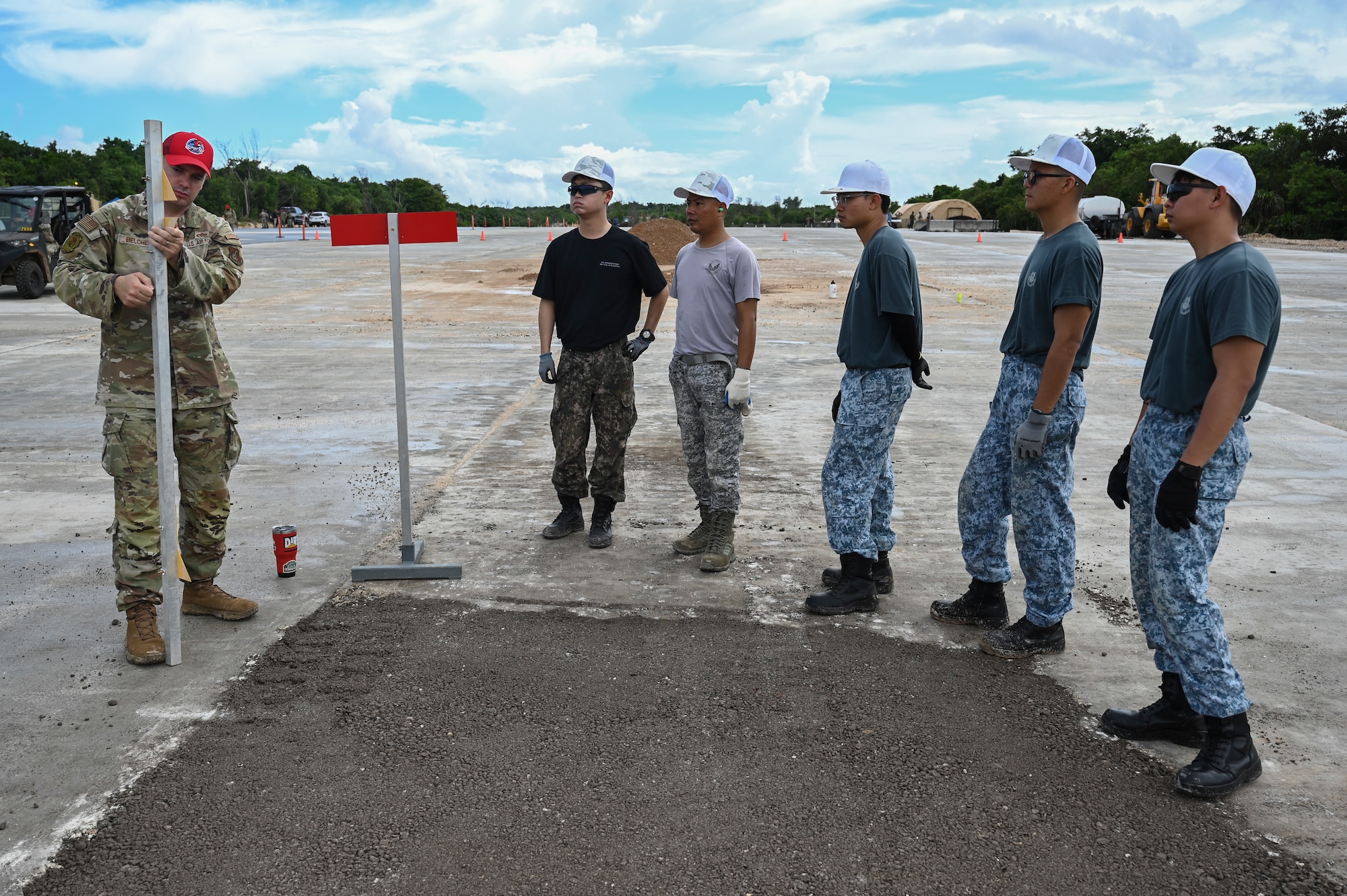 A U.S. Air Force MSgt. with a REDHORSE hat instructs foreign airmen on civil engineering tasks.