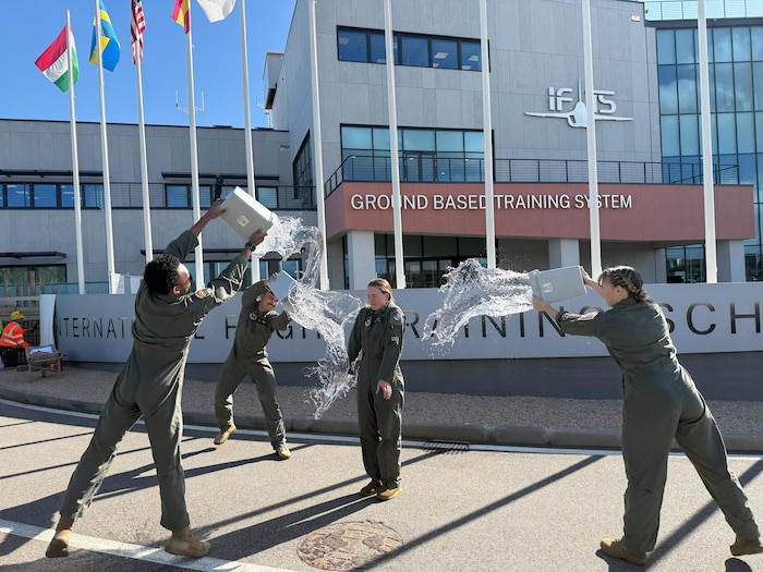 U.S. Air Force student pilots celebrate after completing a T-346A Master Jet Trainer sortie during the undergraduate flying training program Small Group Tryout at the International Flight Training School, Decimomannu Air Base, Italy.