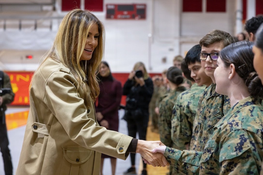 First lady of the United States, Mrs. Melania Trump, engages with a Junior Reserve Marine Corps Officers’ Training Corps (JROTC) cadet at Lejeune High School on Marine Corps Base Camp Lejeune, North Carolina, Nov. 19, 2025. Trump and Vance made their first visit to a military installation under the second Trump Administration to show appreciation for military families and those who serve this holiday season. During their visit they spent time with students creating holiday crafts and building care packages for deployed service members. The visit culminated with the two women addressing nearly 1,500 service members and their families at Marine Corps Air Station New River. (U.S. Marine Corps photo by Lance Cpl. Erica Padgett)