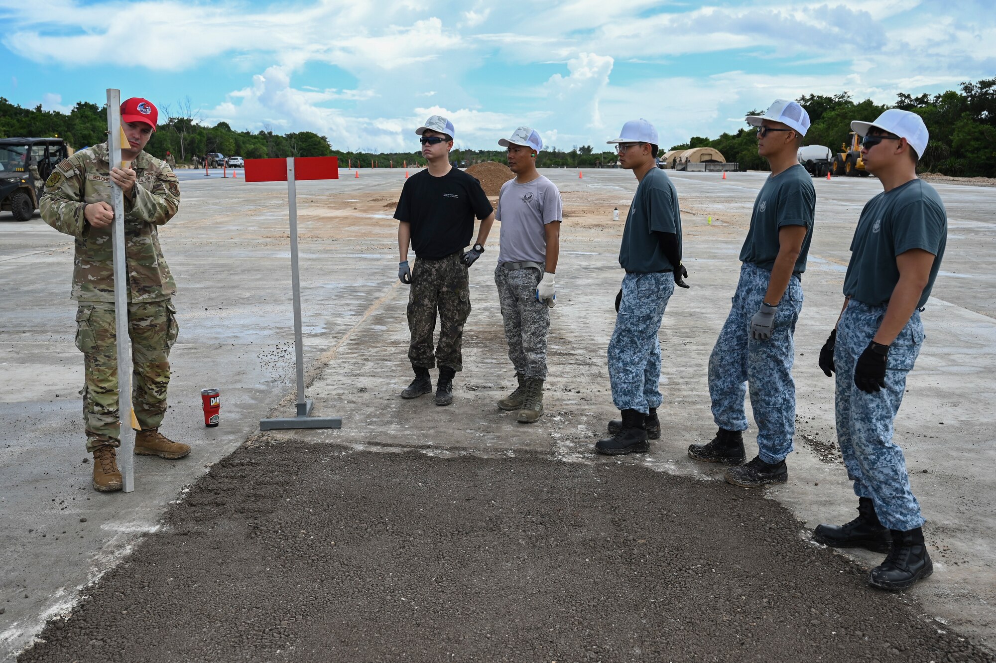 A U.S. Air Force MSgt. with a REDHORSE hat instructs foreign airmen on civil engineering tasks.