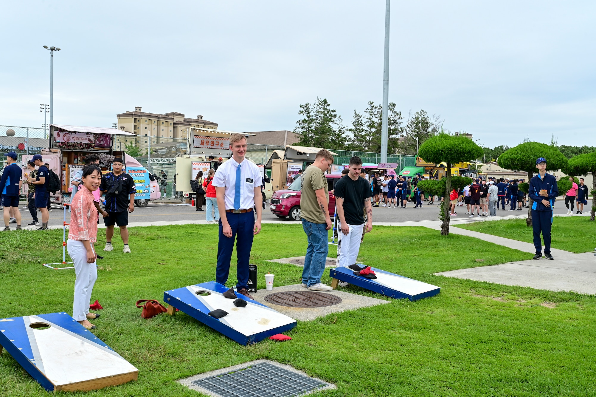 People stand by cornhole boards.
