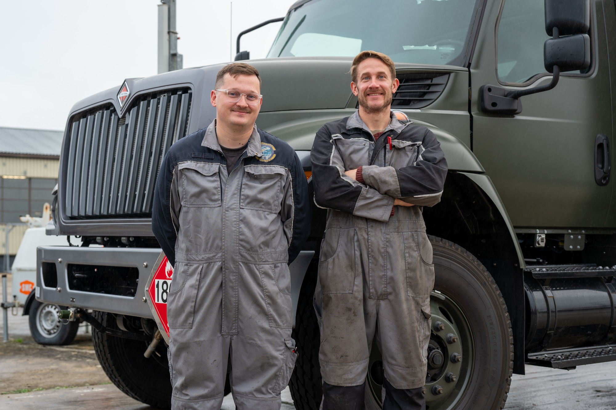 Charles Brett, a main workshop mechanic, and Calvin Gardner, a fire vehicle team lead, both assigned to the 420th Air Base Squadron Logistics Readiness Flight Vehicle Management shop, pose for a photo at RAF Fairford, England, Oct. 16, 2025. The shop maintains and repairs vehicles that support aircraft, airfield operations and base logistics. (U.S. Air Force photo by Airman 1st Class Adam Enbal)