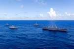 Japan Maritime Self-Defense Force Hyuga-class helicopter destroyer, JS Hyuga, leads United States Navy Arleigh Burke-class destroyer, USS Fitzgerald (centre-right), Indian Navy Shivalik-class frigate, INS Sahyadri (centre-left), and Royal Australian Navy Anzac-class frigate, HMAS Ballarat, during Exercise MALABAR 25 off the coast of Guam.