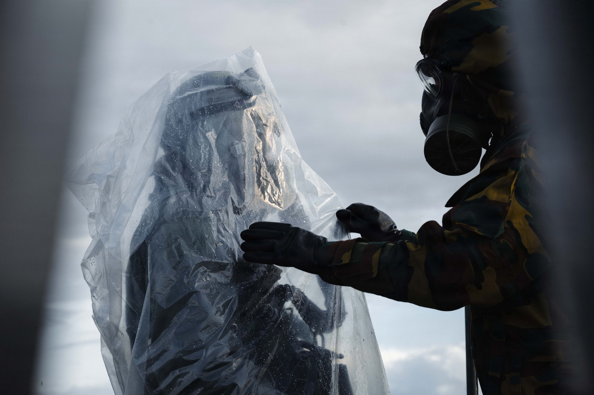 U.S. Air Force Tech. Sgt. Arlin Anderson, left, 52nd Operations Support Squadron aircrew flight equipment lead trainer, enters a decontamination line led by a Belgian air force service member during exercise Toxic Trip 25, at Ørland Air Base, Norway, Sept. 23, 2025. TT25 is designed to improve Chemical, Biological, Radiological, Nuclear defense and capabilities between Allies and partners by conducting real-world scenarios, demonstrations and multinational information exchanges. Through repetitive training and proactive defensive operations, Airmen reduce the potential for loss of life and other vulnerabilities. (U.S. Air Force photo by Senior Airman Sabrina Fuller-Judd)