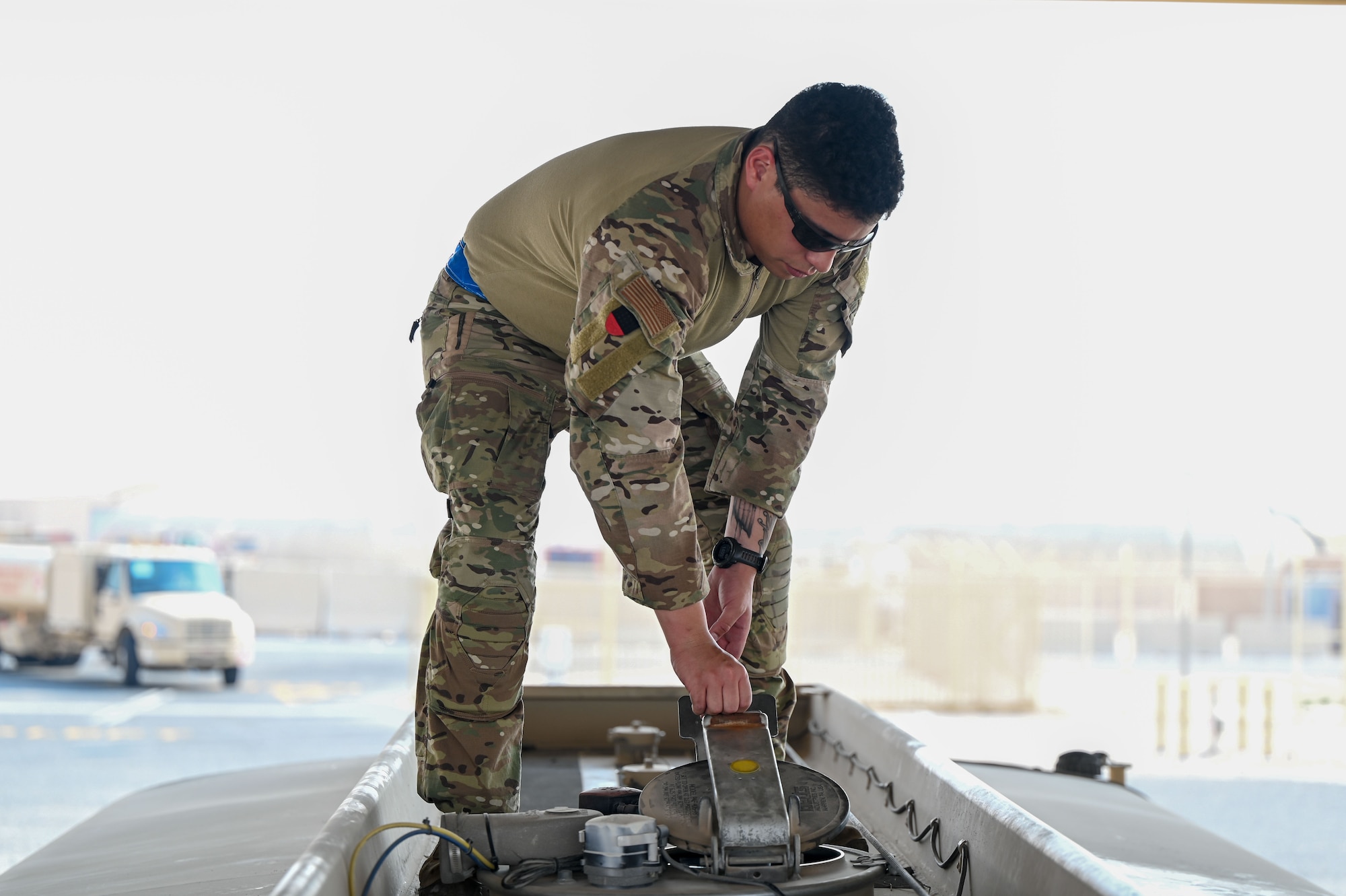 An Airman closes a hatch on top of a refueling truck