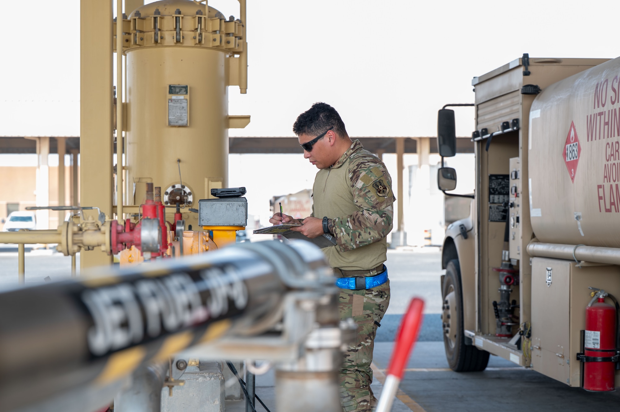 An Airman writes notes on a sheet of paper