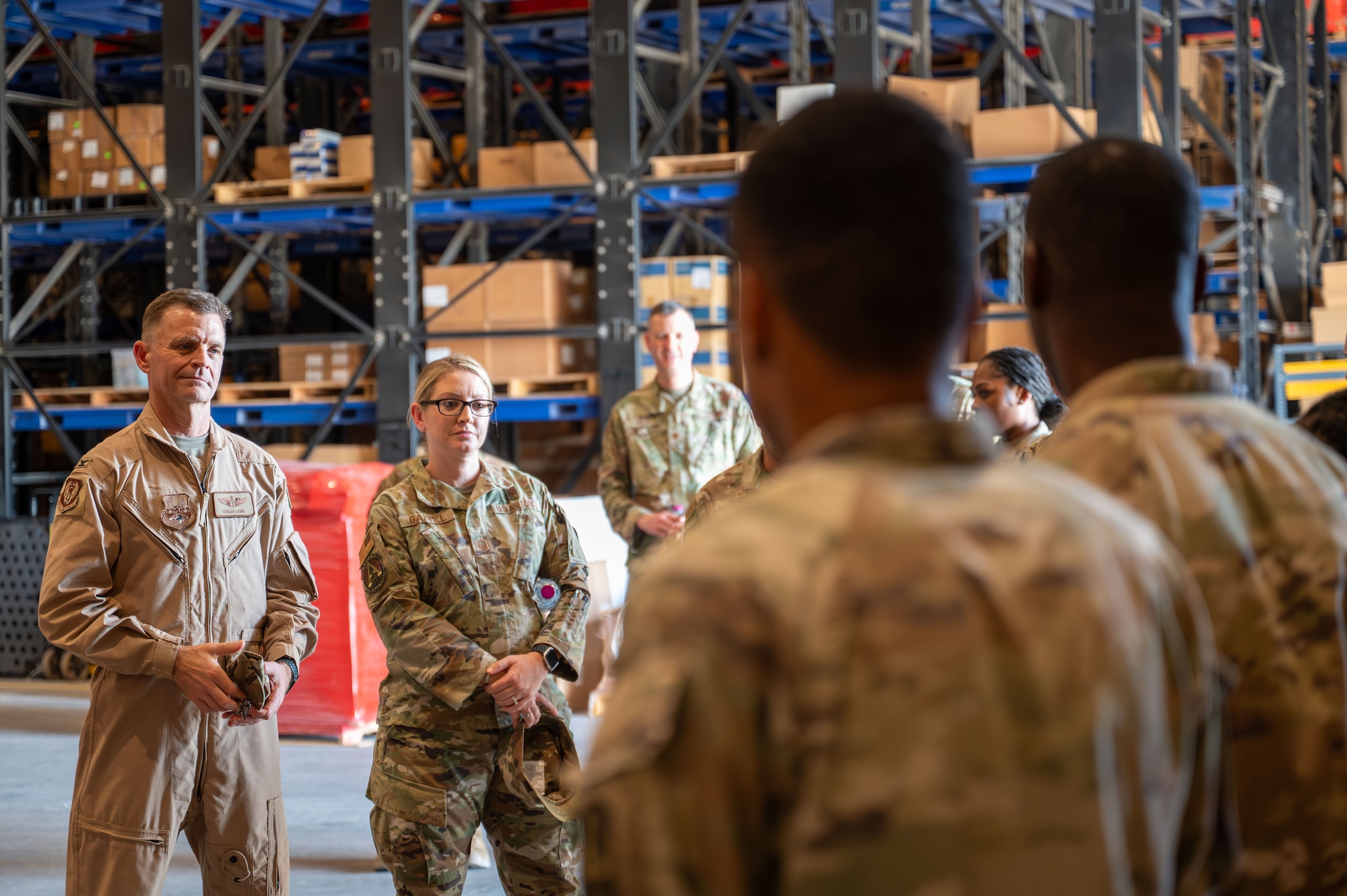 Two U.S. Air Force members stand while soldiers in the foreground brief