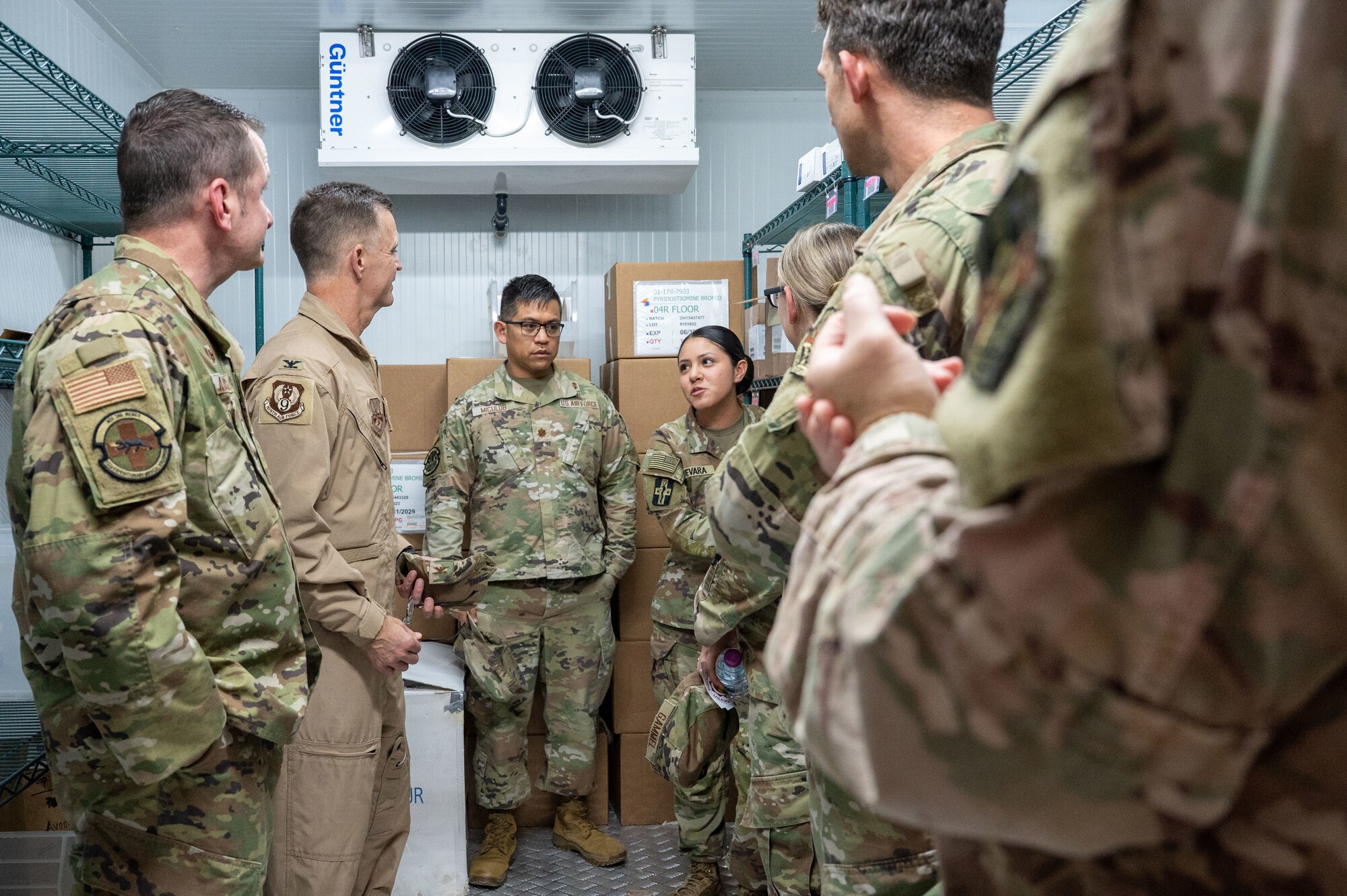 A group of Airmen stand in a cold storage container
