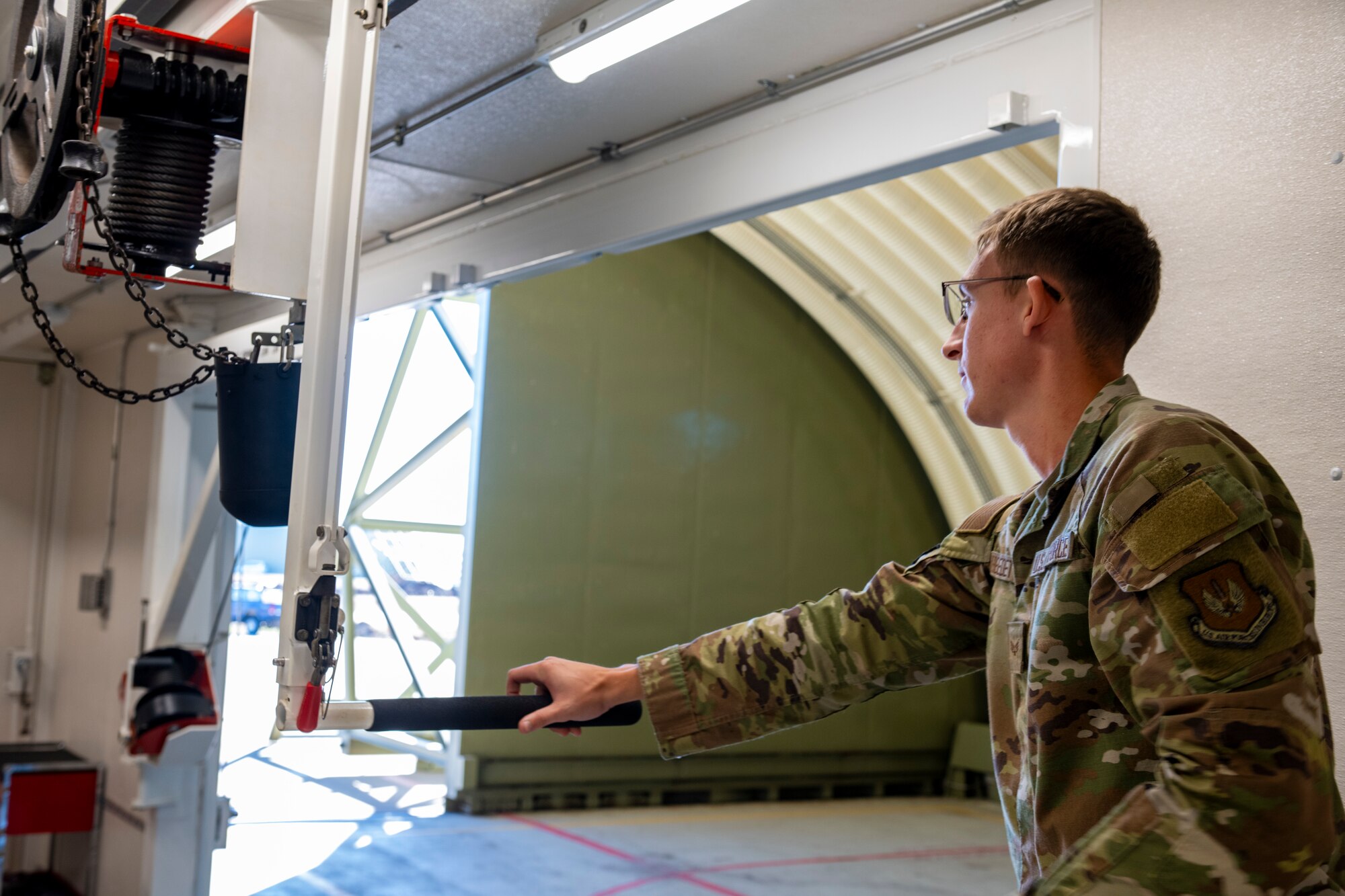 A service member operates a maintenance hoist system
