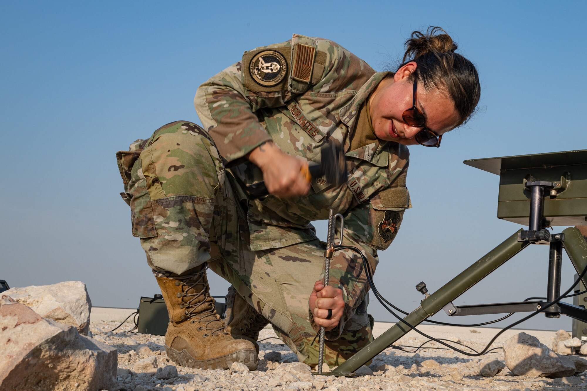 An Airman hammers a stake into the ground