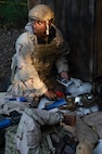 A photo of an Airman looking to the side while holding a notebook with medical gear in front of them.