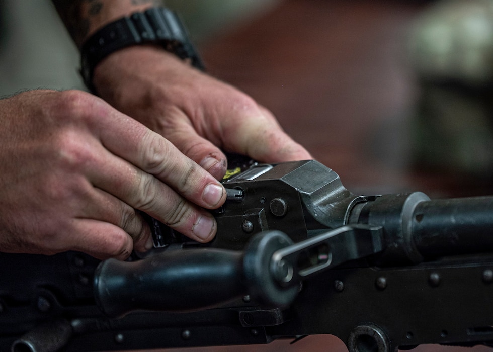 A U.S. Air Force Airman assigned to the 820th Base Defense Group fits a pin into a weapon during a weapons reassembly exercise at Moody Air Force Base, Georgia, Oct. 7, 2025. During the Ranger Assessment and Preparation Course, Airmen practiced field stripping and reassembling M240B and M249 machine guns to sharpen their weapons handling skills and tactical proficiency. (U.S. Air Force photo by Senior Airman Leonid Soubbotine)