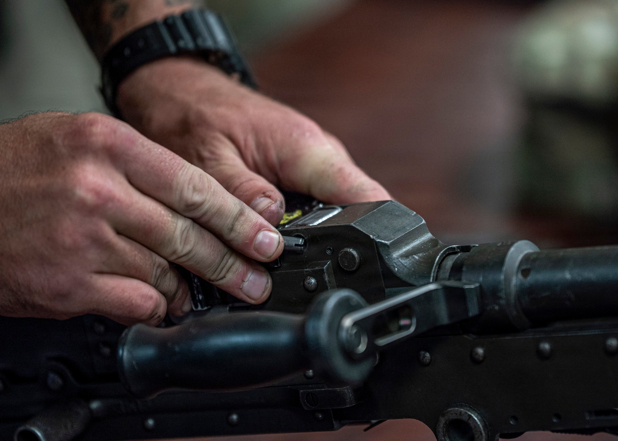 A U.S. Air Force Airman assigned to the 820th Base Defense Group fits a pin into a weapon during a weapons reassembly exercise at Moody Air Force Base, Georgia, Oct. 7, 2025. During the Ranger Assessment and Preparation Course, Airmen practiced field stripping and reassembling M240B and M249 machine guns to sharpen their weapons handling skills and tactical proficiency. (U.S. Air Force photo by Senior Airman Leonid Soubbotine)