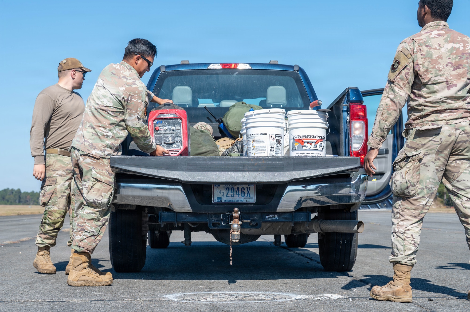 A photo of Airmen unloading equipment out of the back of a truck.