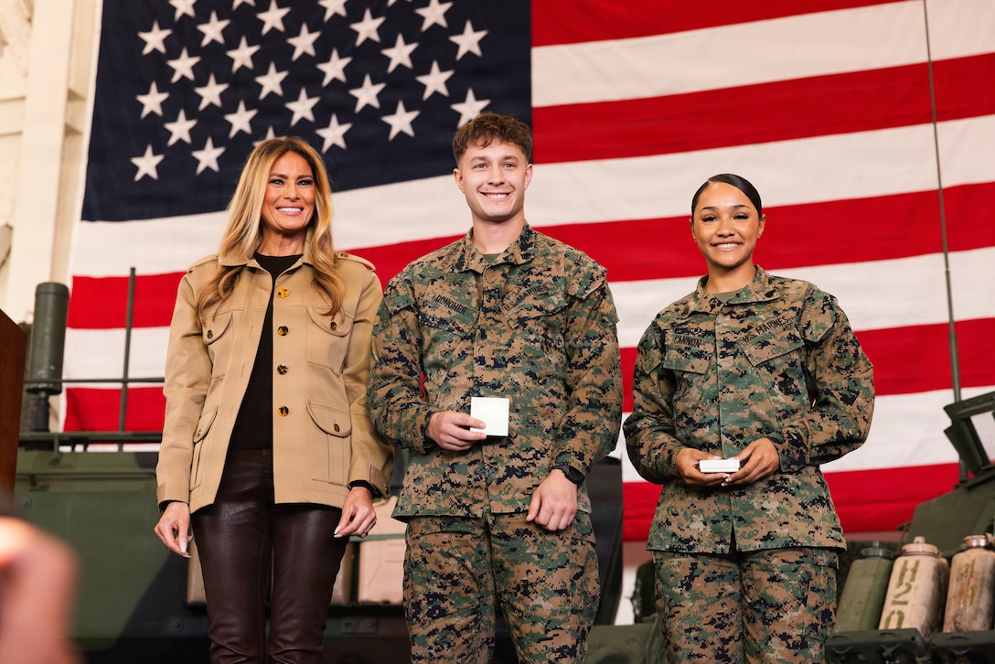 First lady of the United States, Mrs. Melania Trump, poses for a photo with two U.S. Marines at Marine Corps Air Station (MCAS) New River in Jacksonville, North Carolina, Nov. 19, 2025. Trump and Mrs. Usha Vance made their first visit to a military installation under the second Trump Administration to show appreciation for military families and those who serve this holiday season. During their visit they spent time with students creating holiday crafts and building care packages for deployed service members. The visit culminated with the two women addressing nearly 1,500 service members and their families at MCAS New River. (U.S. Marine Corps photo by Cpl. Loriann Dauscher)