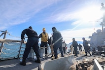 U.S. Navy Sailors assigned to Arleigh Burke-class guided-missile destroyer USS Paul Ignatius (DDG 117) heave a mooring line as the ship arrives in Toulon, France, Nov. 20, 2025.