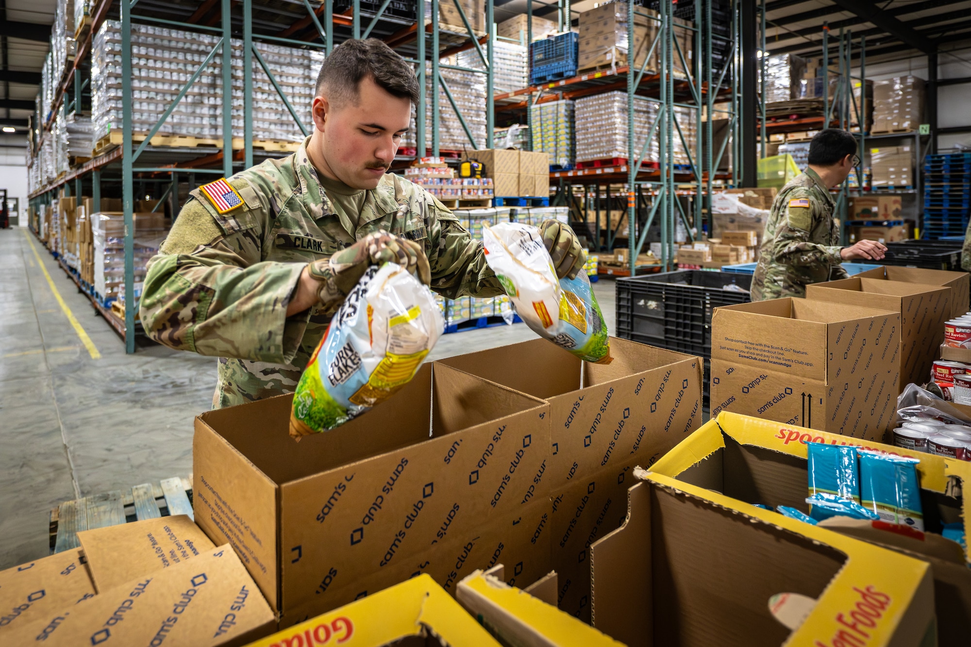 U.S. Army Staff Spc. Kyle Clark from the Kentucky National Guard’s Joint Force Headquarters-Kentucky packs boxes with free groceries at the Dare to Care Food Bank in Louisville, Ky., Nov. 13, 2025. The boxes, containing canned fruit and vegetables, peanut butter, pasta and other nutritious foods, will be given to Kentuckians who are struggling to purchase basic groceries. (U.S. Air National Guard photos by Dale Greer)