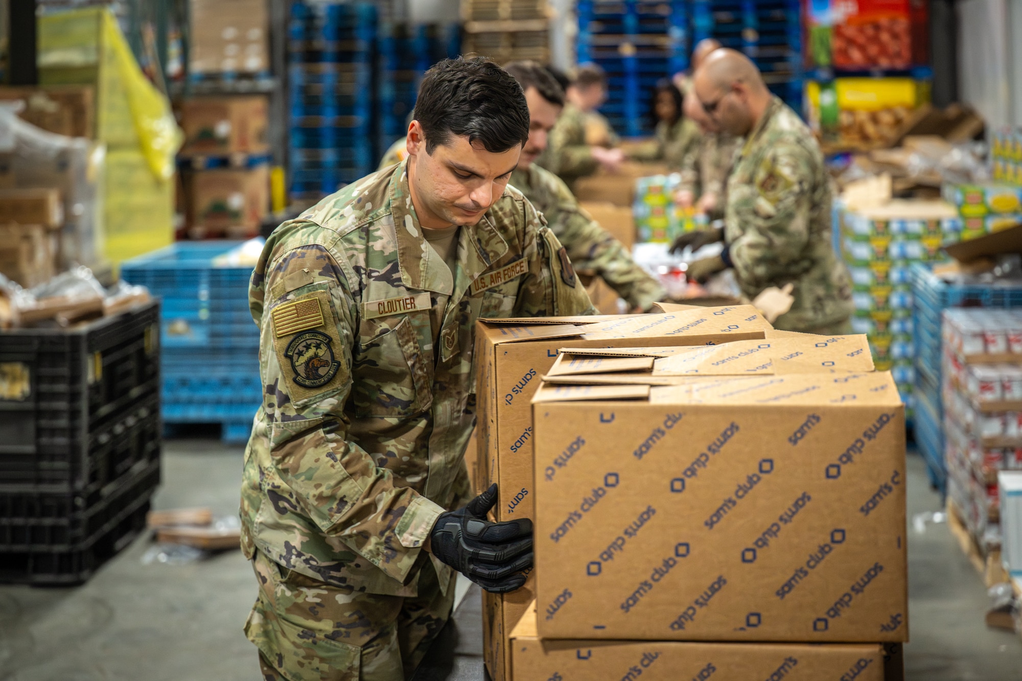 U.S. Air Force Tech. Sgt. Garrett Cloutier from the Kentucky Air National Guard’s 123rd Communications Squadron packs boxes with free groceries at the Dare to Care Food Bank in Louisville, Ky., Nov. 13, 2025. The boxes, containing canned fruit and vegetables, peanut butter, pasta and other nutritious foods, will be given to Kentuckians who are struggling to purchase basic groceries. (U.S. Air National Guard photos by Dale Greer)