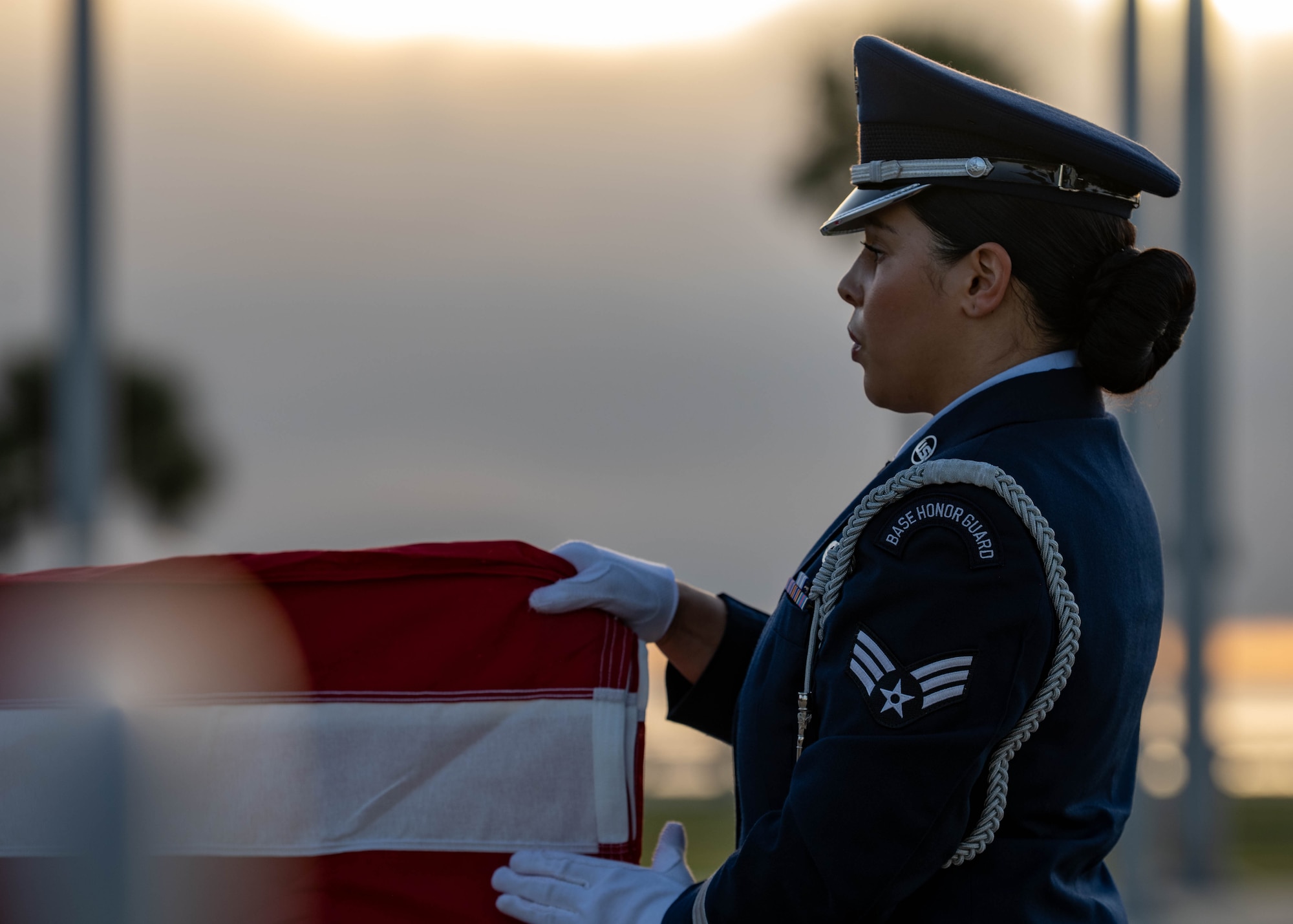 U.S. Air Force Senior Airman Nya Hargis, an honor guardsmen assigned to the 6th Force Support Squadron, performs a flag fold during an honor guard induction ceremony at MacDill Air Force Base, Florida, Oct. 28, 2025. Flag-folding ceremonies are symbolic displays of respect that have developed into a rich military tradition. Flag handlers fold the American Flag 13 times representing the original colonies of the United States, with each fold carrying its own meaning. The flag is folded into a triangular shape with only the blue starred field showing, representing the states that U.S. veterans served while in uniform. (U.S. Air Force photo by Airman 1st Class Monique Stober)