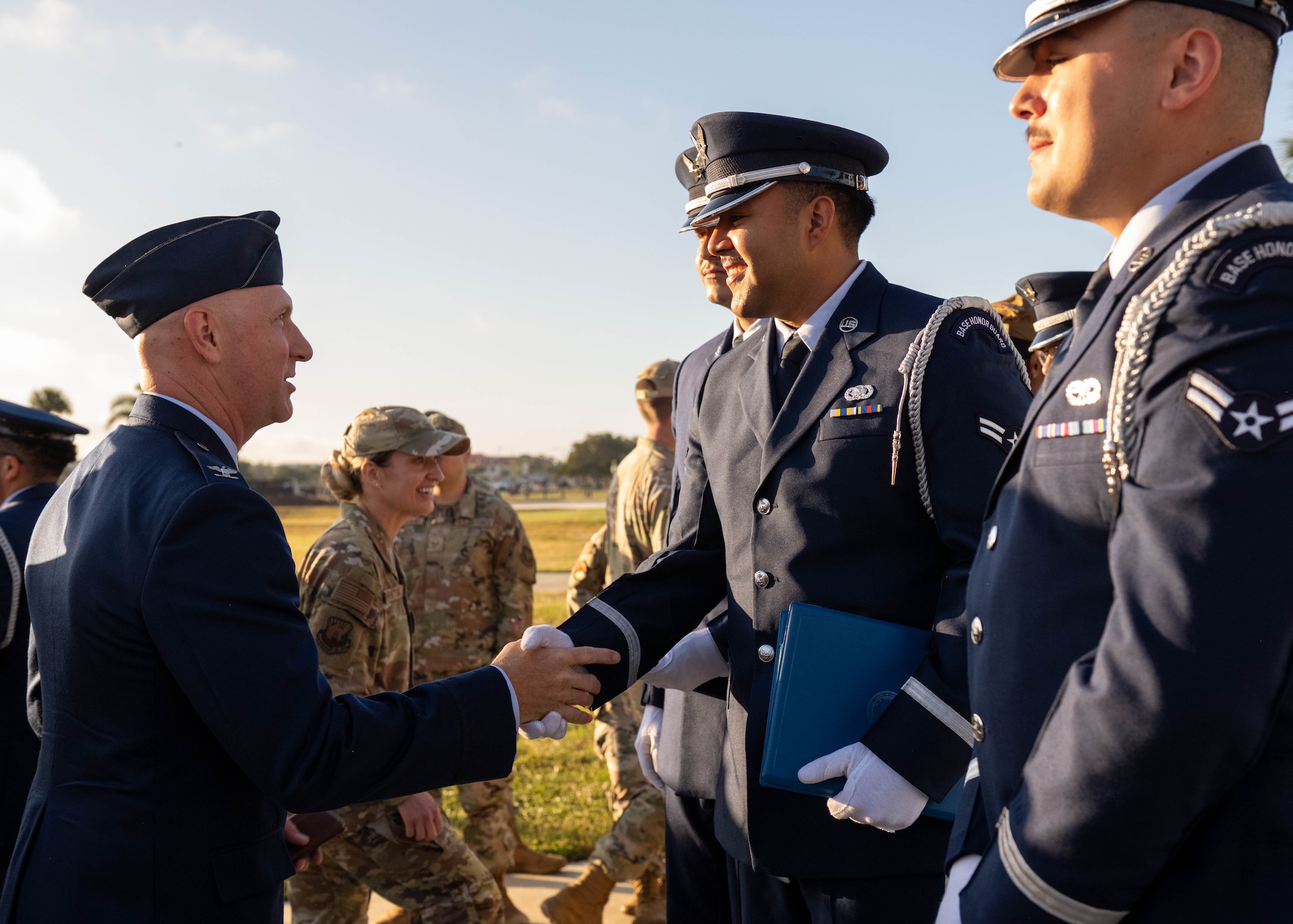 U.S. Air Force Col. Edward Szczepanik, 6th Air Refueling Wing commander, congratulates honor guardsmen assigned to the 6th Force Support Squadron, during an induction ceremony at MacDill Air Force Base, Florida, Oct. 28, 2025. The ceremony marks the culmination of 80 hours of intensive training conducted over 12 days. (U.S. Air Force photo by Airman 1st Class Monique Stober)