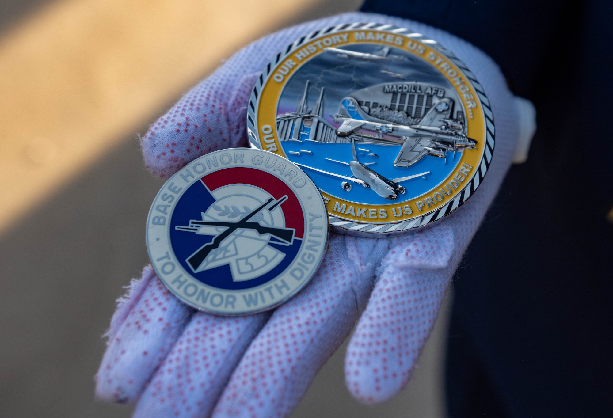 An honor guardsman assigned to the 6th Force Support Squadron, displays coins they received during an induction ceremony at MacDill Air Force Base, Florida, Oct. 28, 2025. The MacDill AFB Honor Guard supports more than 100 ceremonies each year covering 19 counties and approximately 17,504 square miles within Florida, starting at Lake George in the north and running south to Key West. The Honor Guard supports joint partners such as the Army, Navy, Marines and Coast Guard. (U.S. Air Force photo by Airman 1st Class Monique Stober)