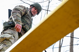 Senior Airman Mark Daley, a vehicle management specialist with the 910th Logistics Readiness Squadron, navigates the narrow path of a Leadership Reaction Course obstacle on Nov. 14, 2025, at Camp James A. Garfield Joint Military Training Center, Ohio.