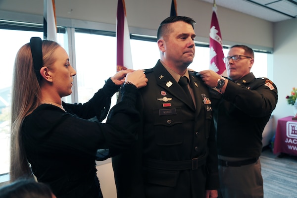 Maj. Matthew Westcott stands at attention while his wife Louise Westcott and U. S. Army Col. Brandon Bowman, U.S. Army Corps of Engineers Jacksonville District Commander pin on his new rank during the promotion of Westcott to Lieutenant Colonel during a promotion ceremony Nov. 13, at the District Headquarters in the Prudential Building.  As Westcott prepares to ascend to the next echelon of leadership within USACE, his promotion is a testament to his unwavering commitment and meritorious service.  (U.S. Army photo by Mark Rankin)