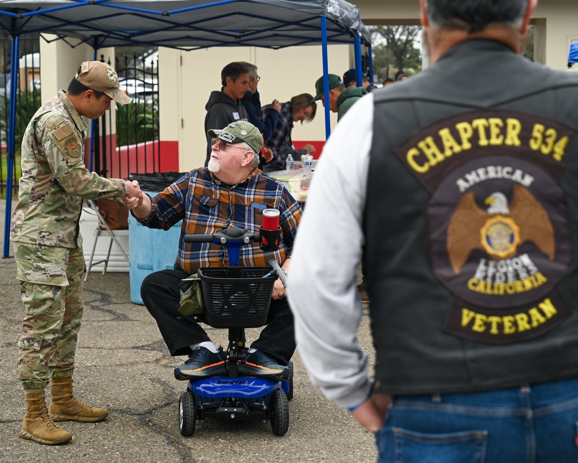A U.S. Air Force active-duty service member from Vandenberg Space Force Base meets with a veteran and shakes his hand.
