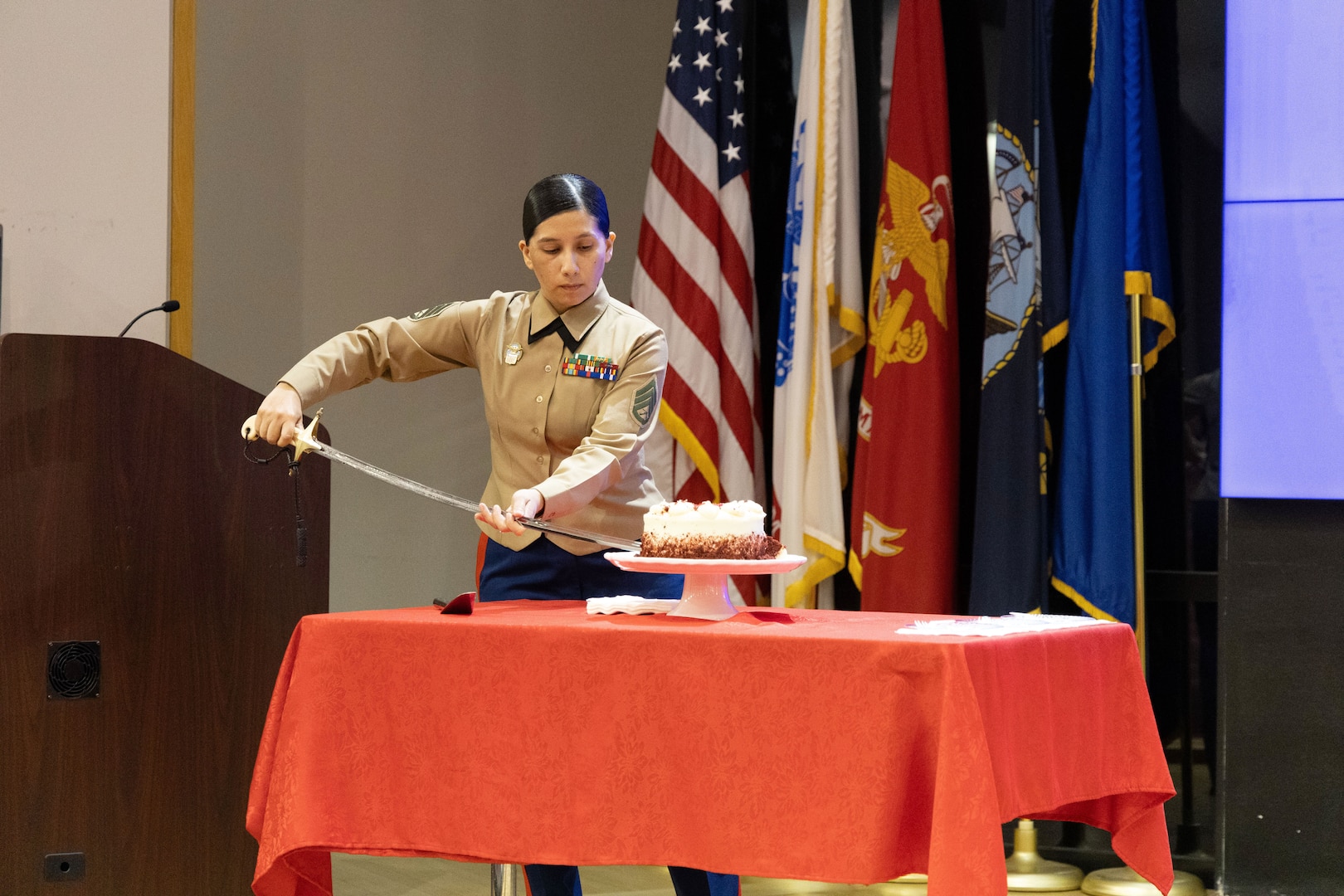 Female Marine cuts cake with sword