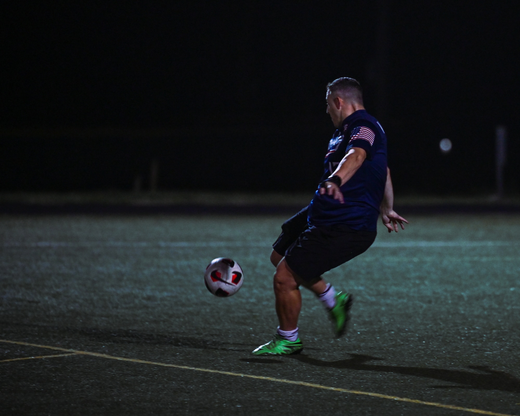 U.S. Air Force Maj. Austin Van Hoesen, 576th Flight Test Squadron flight commander, kicks a soccer ball.