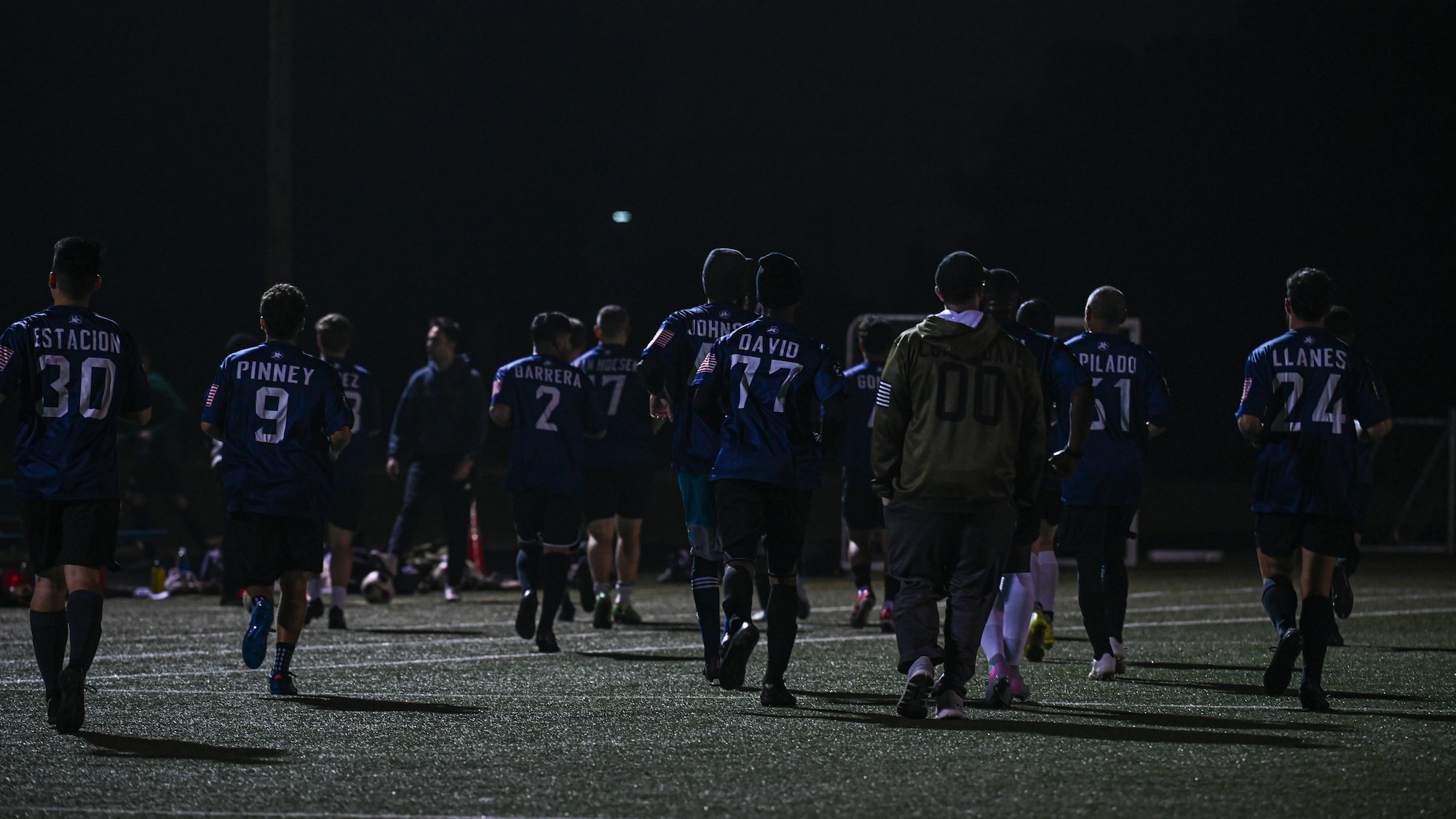 Vandenberg Space Force Base Hawks’ varsity soccer team players run warmups on the field before a scrimmage.