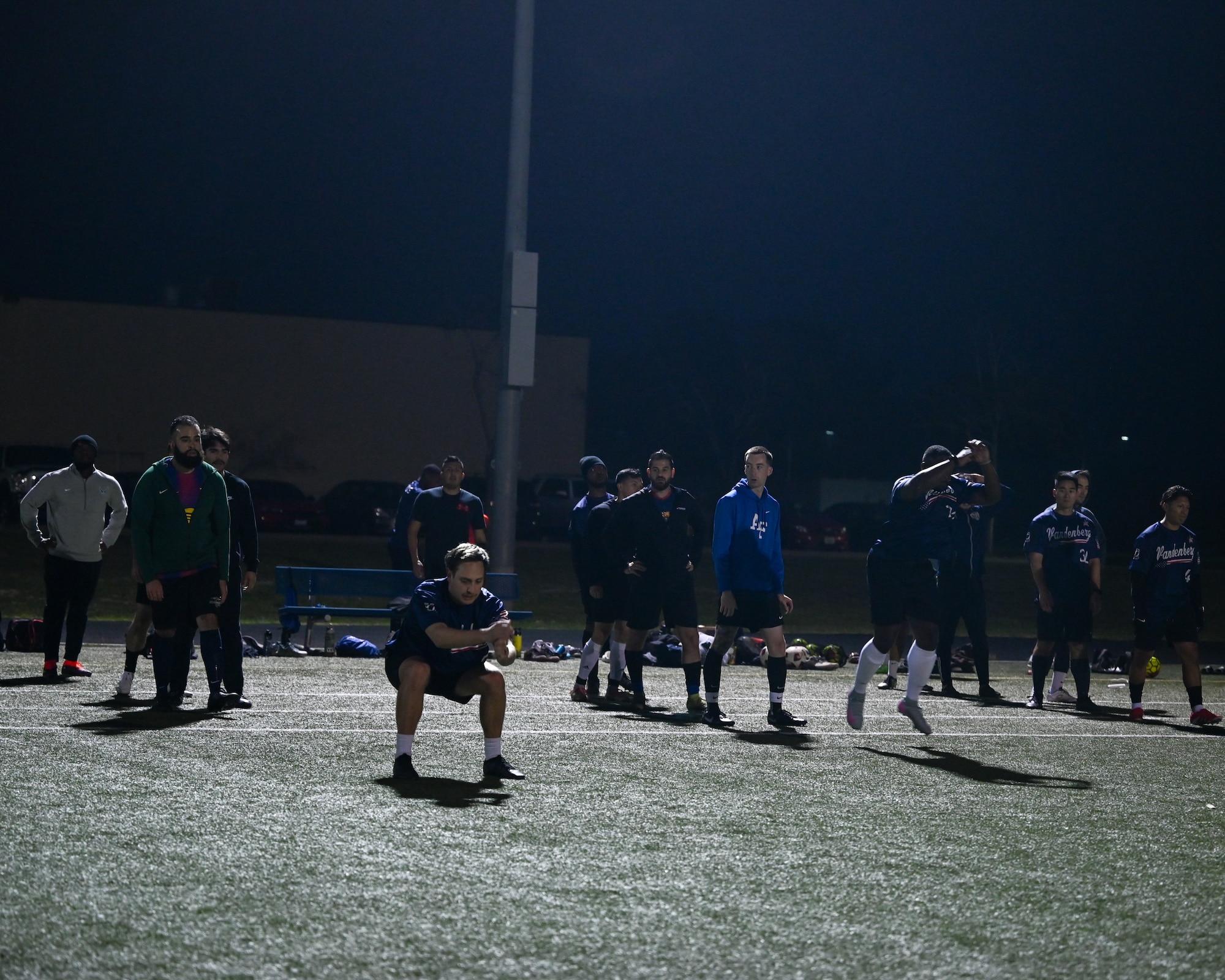 Soccer players line up and jump forward during warm-ups.