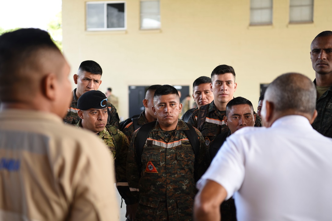 People in military uniforms stand in a circle