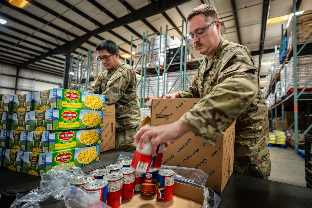 U.S. Army Staff Sgt. Brandon Tagarook, left, of the Kentucky Army National Guard’s 202nd Army Band, and U.S. Air Force Tech. Sgt. Alex Koehler of the Kentucky Air National Guard’s 123rd Contingency Response Group pack boxes with free groceries at the Dare to Care Food Bank in Louisville, Ky., Nov. 13, 2025. The boxes, containing canned fruit and vegetables, peanut butter, pasta and other nutritious foods, will be given to Kentuckians who are struggling to purchase basic groceries. (U.S. Air National Guard photos by Dale Greer)