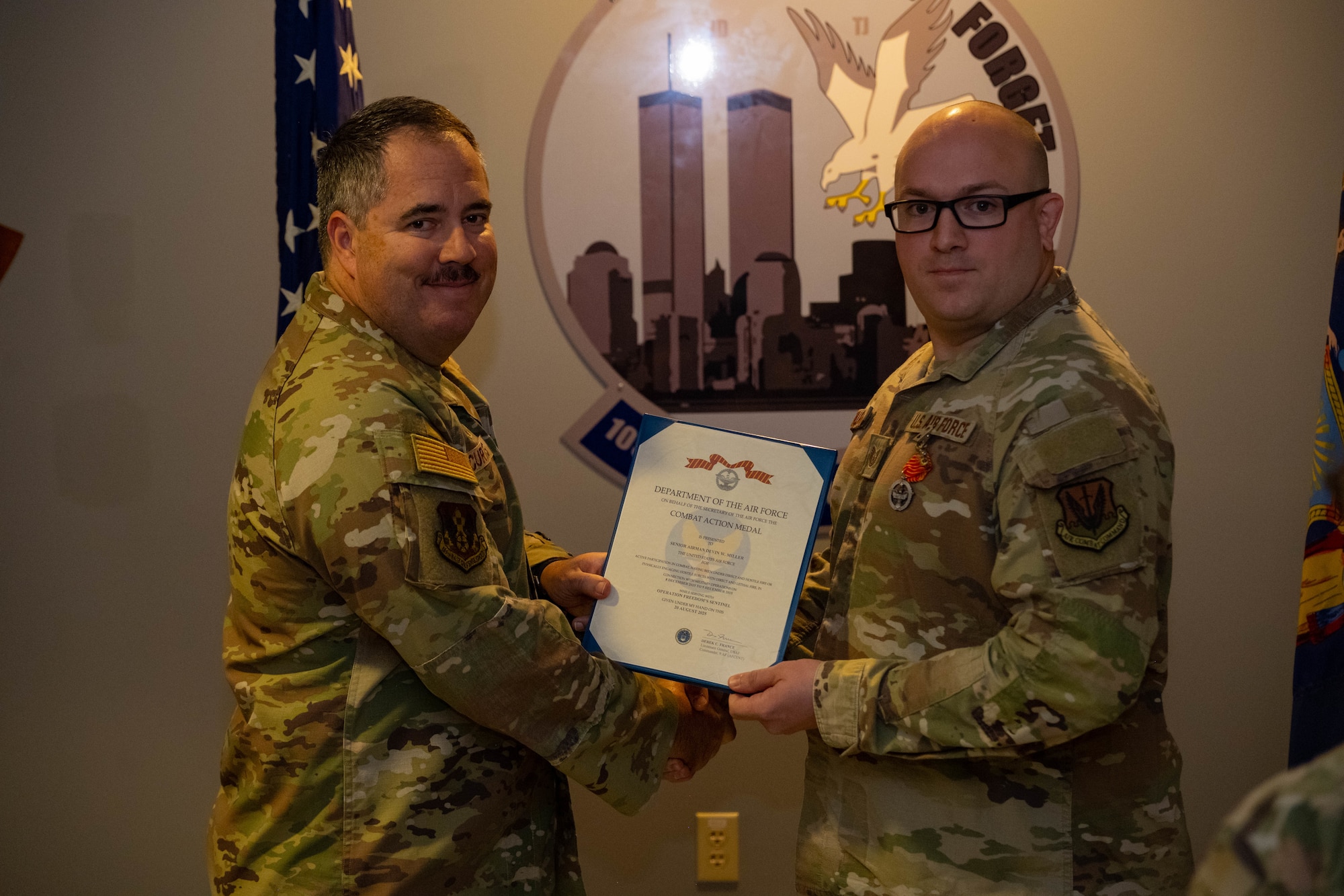Lt. Col. Michael Curtis awards Tech. Sgt. Devin Miller with the Air Force Combat Action Medal.