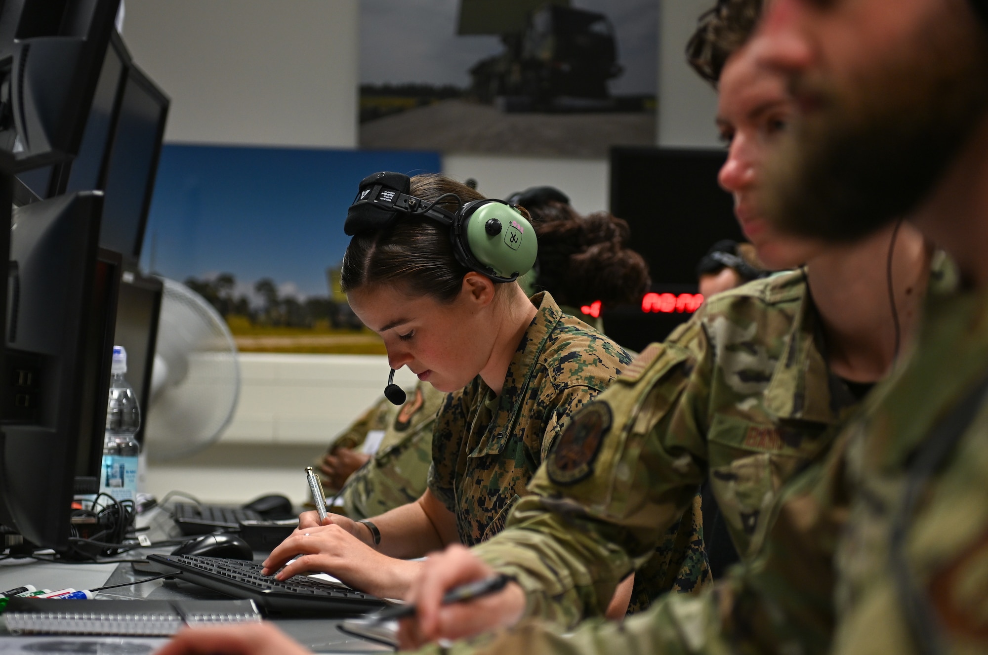 U.S. Marine Corps 1st Lt. Marguerite Schillinger, Marine Air Support Squadron 3 interface control cell director, records information during SPARTAN SHIELD 25-2 at Einsiedlerhof Air Station, Germany, September 25, 2025. SPARTAN SHIELD 25-2 integrated the joint-kill chain from sensor-to-shooter and the associated tactical air command and control into a theater-specific integrated air missile and defense scenario for U.S. Army, U.S. Marine Corps, and U.S. Air Force participants. (U.S. Air Force photo by Capt. Benjamin Aronson)